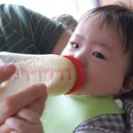 パパにミルクをもらっている赤ちゃん