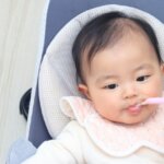 よだれかけをして離乳食を食べる
